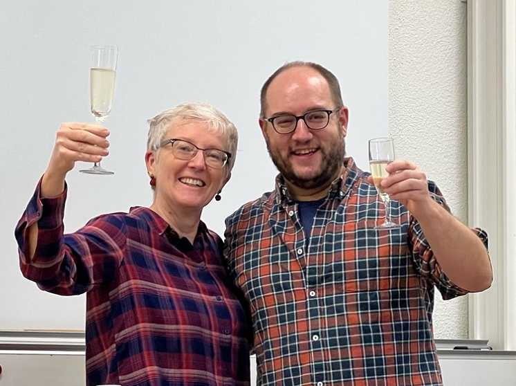 Enlarged view: Man and woman smiling and cheering with a glass of prosecco
